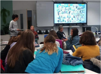 Schülerinnen der Montessori-Schule Penzberg hören im Klassenzimmer dem Schulvortrag über die Arbeit von Amnesty International zu.